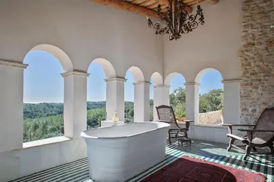 a bath tub in a room with arched windows at Alcazar Del Garraf in Olivella