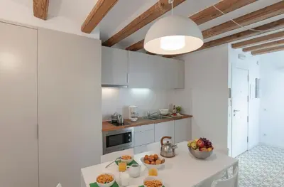 a kitchen with white cabinets and a table with fruit on it at Central Azulete in Barcelona