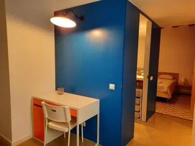 a blue wall in a room with a table and chair at Central Azulete in Barcelona