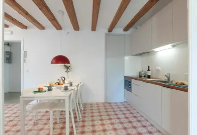a white kitchen with a white table and chairs at Central Azulete in Barcelona