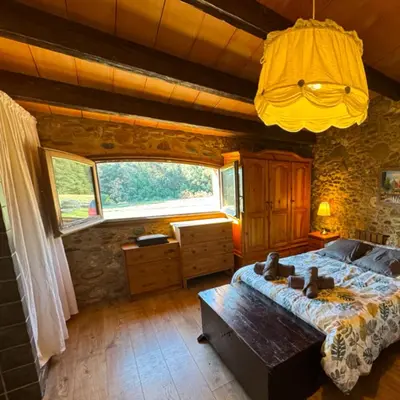 a bedroom with a large bed and a large window at Ca l'Esclatat in Santa María de Palautordera