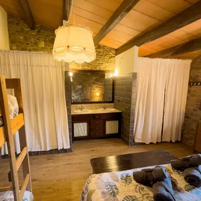 a bedroom with a bed and a bathroom with a sink at Ca l'Esclatat in Santa María de Palautordera