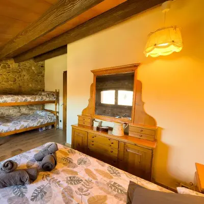 a bedroom with a bed and a dresser and a window at Ca l'Esclatat in Santa María de Palautordera
