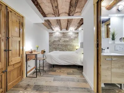 a bedroom with a bed and a stone wall at Concordia - Beautiful flat, spacious, central 4 rooms , 2 bath in Barcelona