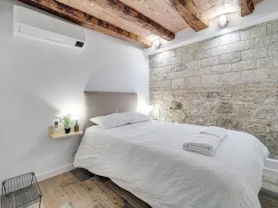 a bedroom with a white bed with a brick wall at Concordia - Beautiful flat, spacious, central 4 rooms , 2 bath in Barcelona