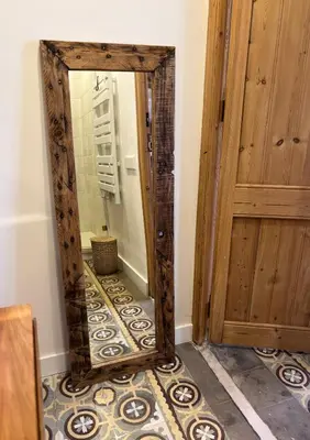 a mirror sitting on a floor in a room at Cozy Suite in a historic house near the sea in Vilanova i la Geltrú