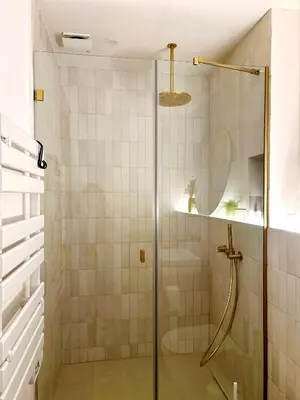 a shower with a glass door in a bathroom at Cozy Suite in a historic house near the sea in Vilanova i la Geltrú