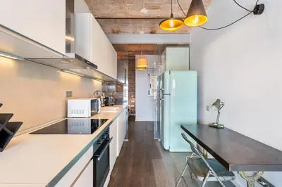 a kitchen with a counter top and a refrigerator at Gràcia Monthly 1BR Sunny Private Terrace in Barcelona