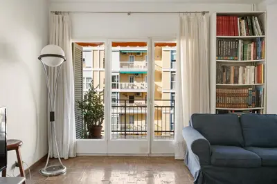 a living room with a blue couch and a window at 180m² 5BR Home Lift Terrace 32 Nights in Barcelona