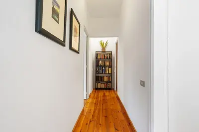 a hallway with a hard wood floor and a book shelf at 180m² 5BR Home Lift Terrace 32 Nights in Barcelona