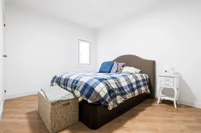 a bedroom with a bed with a blue and white blanket at 55m² Monthly Base w Terrace AC in Barcelona