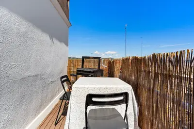 a table and chairs on a balcony with a fence at 55m² Monthly Base w Terrace AC in Barcelona