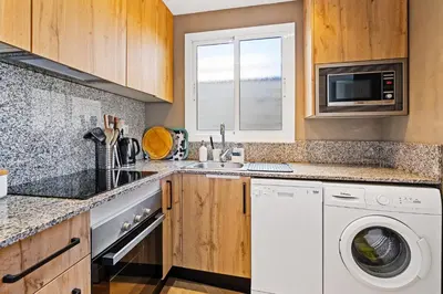 a kitchen with a washing machine and a sink at 55m² Monthly Base w Terrace AC in Barcelona