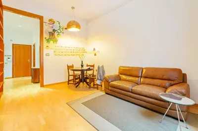 a living room with a brown leather couch and a table at Quiet, vibrant 2 bedroom in pedestrian Eixample in Barcelona