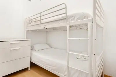 a bedroom with two bunk beds and a desk at 5BR for 7 Elevator Walk to Sant Antoni in Barcelona