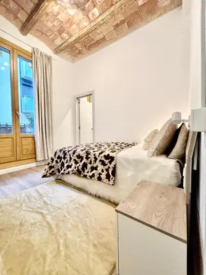 a living room with a couch and a bed at Piso en gracia de 3 habitaciones dobles suits in Barcelona