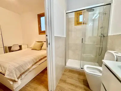 a bedroom with a bed and a glass shower at Piso en gracia de 3 habitaciones dobles suits in Barcelona