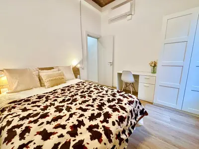 a bedroom with a black and white bed and a desk at Piso en gracia de 3 habitaciones dobles suits in Barcelona