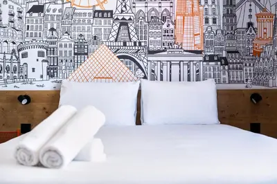 a bedroom with a white bed with two pillows at easyHotel Barcelona La Sagrera in Barcelona