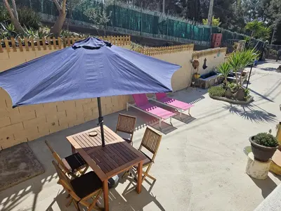 a patio with a table and an umbrella at Casa del Campo in Els Hostalets
