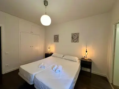 a bedroom with a large white bed with two towels on it at Spacious 1 br home in Bonanova in Barcelona