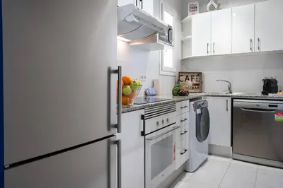a kitchen with white appliances and white cabinets at Habitat Apartments Cool Jazz in Barcelona
