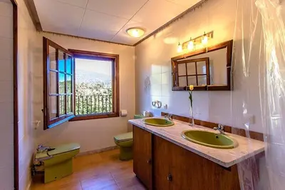 a bathroom with two sinks and a toilet and a window at Casa Rural CAN PANXA in Sant Pere de Vilamajor