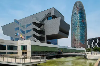 a building with a tower next to a river at City Center Apartment in Barcelona