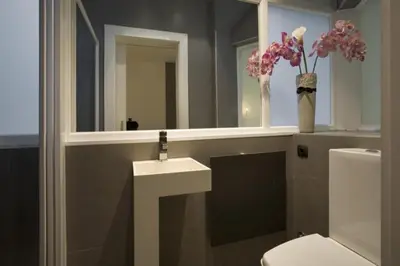 a bathroom with a sink and a toilet and a mirror at City Center Apartment in Barcelona