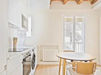 a kitchen with a table and a table and a dining room at Winahost La Barceloneta in Barcelona