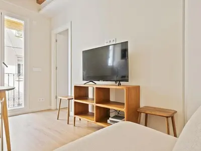 a living room with a flat screen tv on a stand at Winahost La Barceloneta in Barcelona