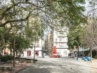 a city street with trees and blue balloons and buildings at Winahost La Barceloneta in Barcelona