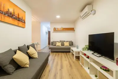a living room with a couch and a flat screen tv at Apartamento 3 hab Fira de Bcn a 20 minutos de Bcn Centro in Hospitalet de Llobregat