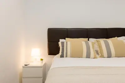 a bedroom with a bed with a black headboard and pillows at Apartamento 3 hab Fira de Bcn a 20 minutos de Bcn Centro in Hospitalet de Llobregat