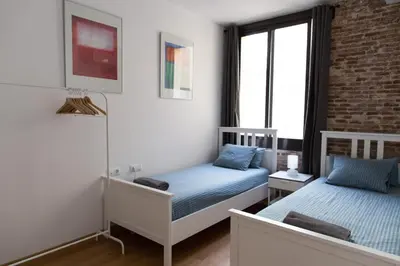 a bedroom with two beds and a brick wall at Central Apartment in Barcelona
