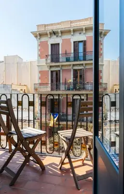 a balcony with two chairs and a table and a building at Nice apartment in Gracia - Torrent de l'Olla in Barcelona