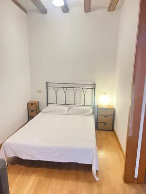 a bedroom with a white bed and a wooden floor at Flat in centre of Barcelona in Barcelona