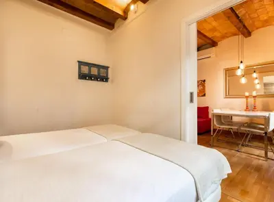 a bedroom with a white bed and a desk at Blasco de Garay: acogedor apartamento en el corazón de Poble-sec in Barcelona