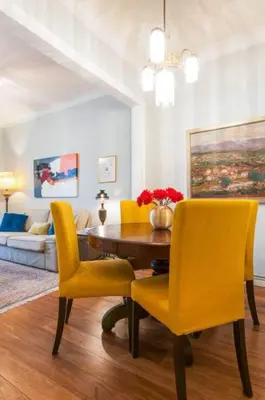 a dining room with a table and yellow chairs at Explore City Center from an Elegant Urban Retreat in Barcelona