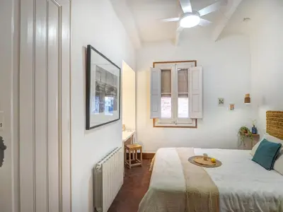 a bedroom with a bed and a ceiling fan at Las Ventanas Sea Front by Hello Homes Sitges in Sitges