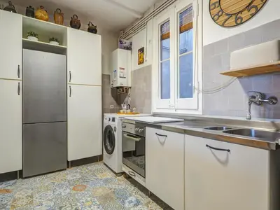 a kitchen with white cabinets and a sink and a dishwasher at Las Ventanas Sea Front by Hello Homes Sitges in Sitges