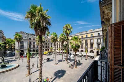 a city square with palm trees and buildings at Hostal Ambos Mundos in Barcelona