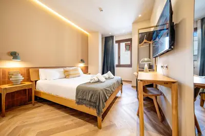 a bedroom with a bed and a desk and a television at Hostal Ambos Mundos in Barcelona