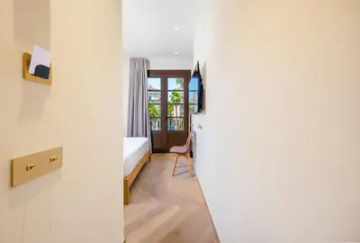 a small room with a bed and a window at Hostal Ambos Mundos in Barcelona