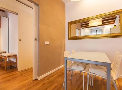 a dining room with a table and chairs and a mirror at Tapioles · Lovely apartment in Poble Sec in Barcelona