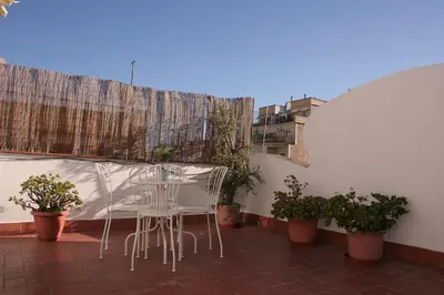 a table and chairs on a balcony with potted plants at Urgell - Lovely apartment with a terrace in Barcelona