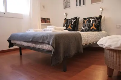 a bed with a blanket on it in a room at Urgell - Lovely apartment with a terrace in Barcelona