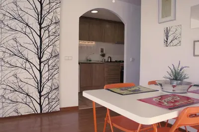 a kitchen and dining room with a white table and orange chairs at Urgell - Lovely apartment with a terrace in Barcelona
