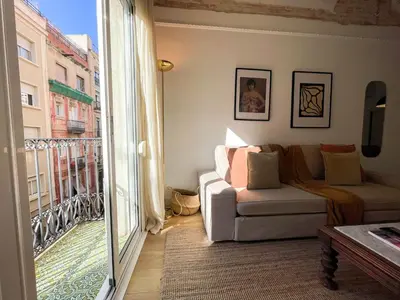 a living room with a couch and a balcony at Boutique Radas in Barcelona