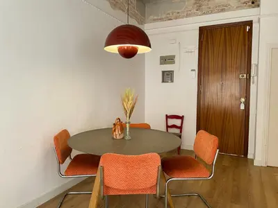 a dining room with a table and orange chairs at Boutique Radas in Barcelona